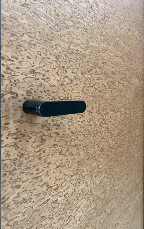 Warm stone-look door finish with a black handle