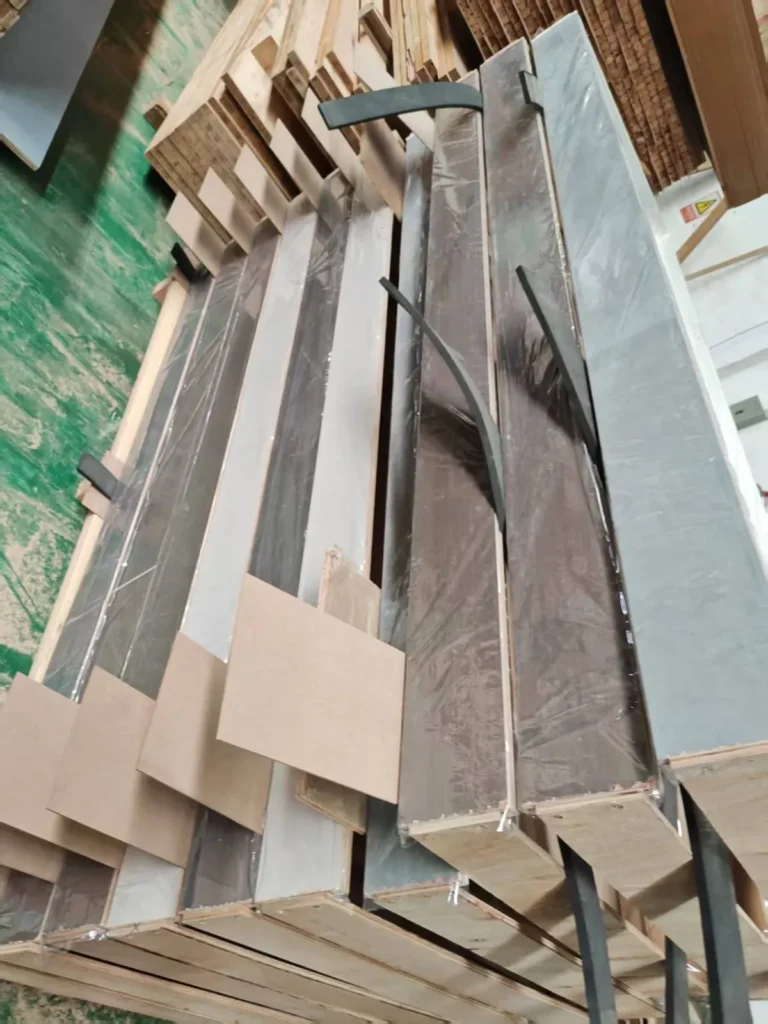 Door frame parts wrapped in film with cardboard corner protectors, ready for shipping