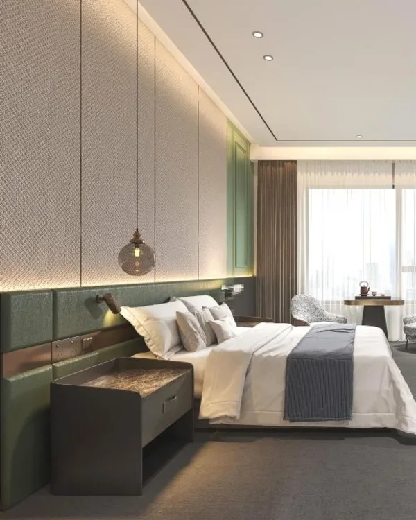 Hotel guestroom with an upholstered headboard wall, nightstand and bed