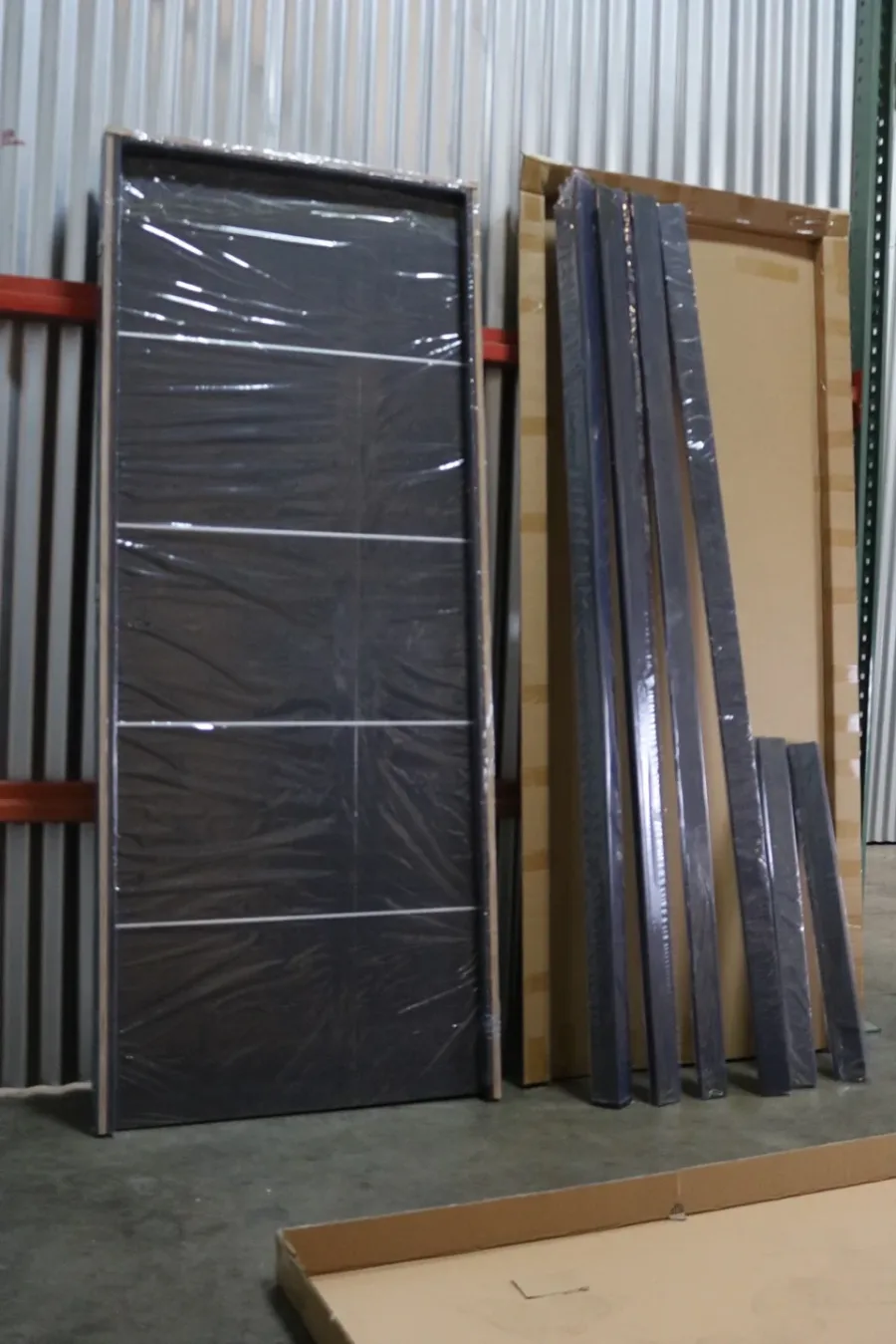 Our in-stock pre-hung door in its frame, standing beside its frame parts